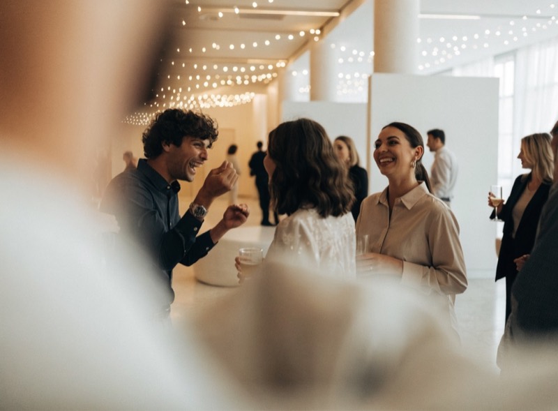 Colleagues mingling at a bright modern corporate party.